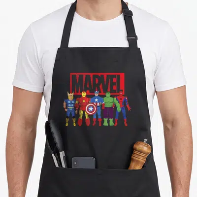 Tablier de cuisine noir avec illustration des Avengers en figurines d'action sous le logo Marvel rouge et gris.