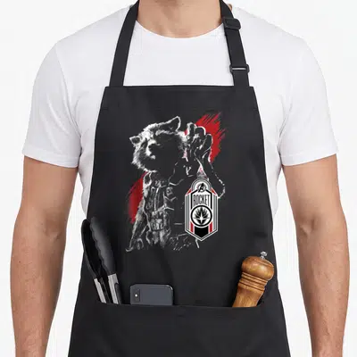 Tablier de cuisine noir avec portrait stylisé de Rocket Raccoon et logo hexagonal aux couleurs rouge et blanc.