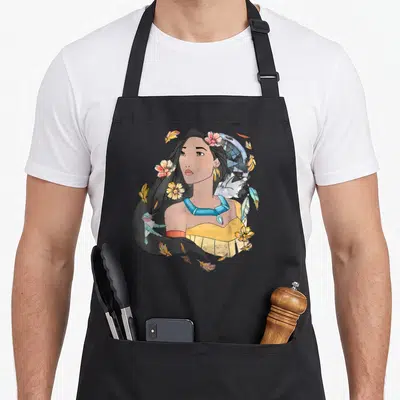 Tablier de cuisine noir avec une illustration de Pocahontas entourée de fleurs et d'un dreamcatcher en aquarelle.