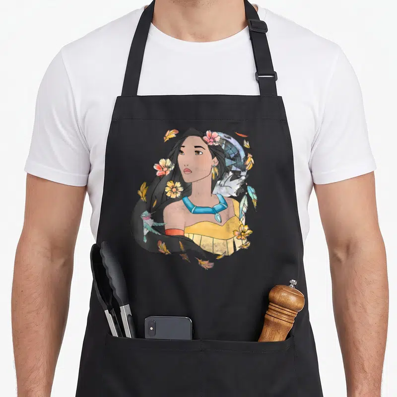 Tablier de cuisine noir avec une illustration de Pocahontas entourée de fleurs et d'un dreamcatcher en aquarelle.