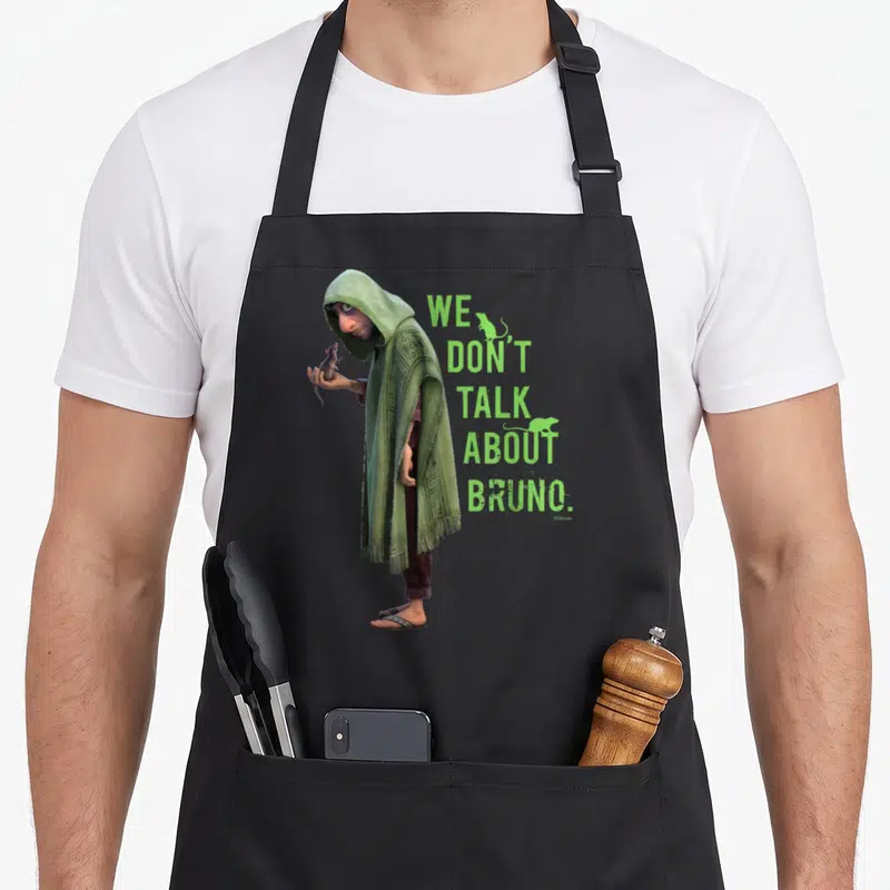 Tablier de cuisine noir avec illustration de Bruno en capuche verte tenant un rat et le texte We Don't Talk About Bruno.