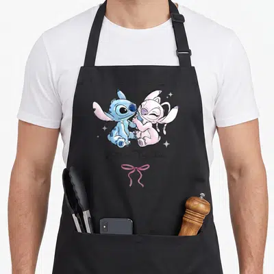 Tablier de cuisine noir avec Stitch et Angel en train de s'enlacer sous le texte Better Together.