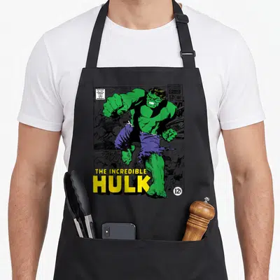 Tablier de cuisine noir avec une illustration vintage du personnage vert et du titre The Incredible Hulk en lettres jaunes.