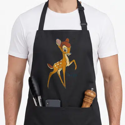 Tablier de cuisine noir avec illustration colorée de Bambi debout et le logoDisney en bas à droite.