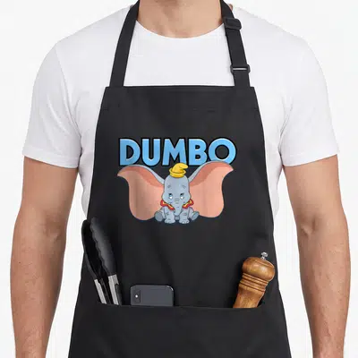 Tablier de cuisine noir avec illustration de Dumbo assis et texte bleu en arrière-plan.