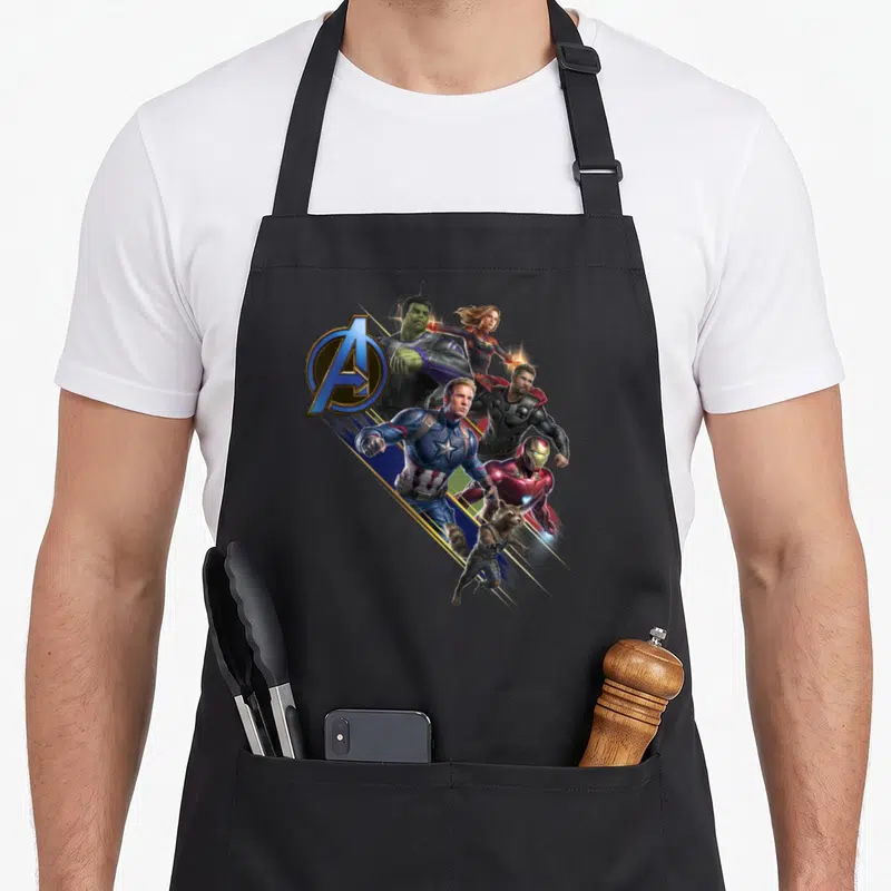 Tablier de cuisine noir avec le logo des Avengers et plusieurs super-héros en pleine action.