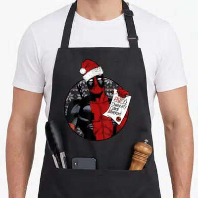 Tablier de cuisine noir avec Deadpool en bonnet de Noël tenant une liste où la case Heroic est cochée.