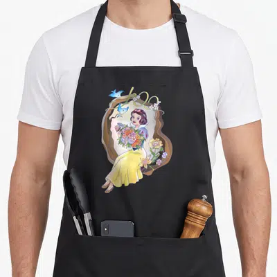 Tablier de cuisine noir avec Blanche-Neige tenant un bouquet floral sous le chiffre 100 orné d'oiseaux bleus.
