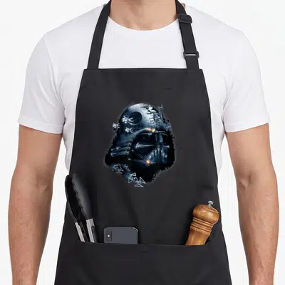 Tablier de cuisine noir avec illustration masquée par des vaisseaux spatiaux et la Death Star en nuances de bleu.