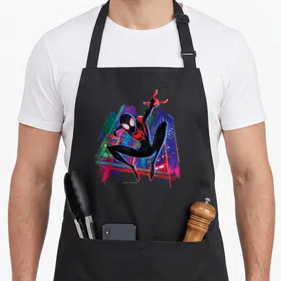 Tablier de cuisine noir avec Miles Morales en saut au-dessus d'un décor de ville aux couleurs vives et style graffiti.