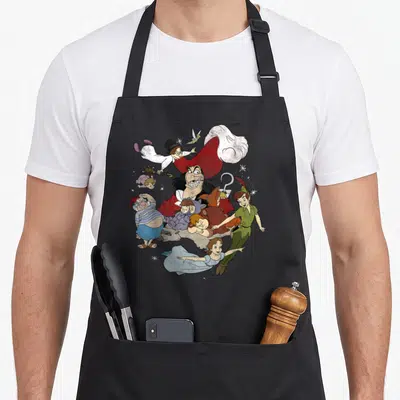 Tablier de cuisine noir avec illustration colorée de Peter Pan, le Capitaine Crochet et Tinker Bell en plein vol.
