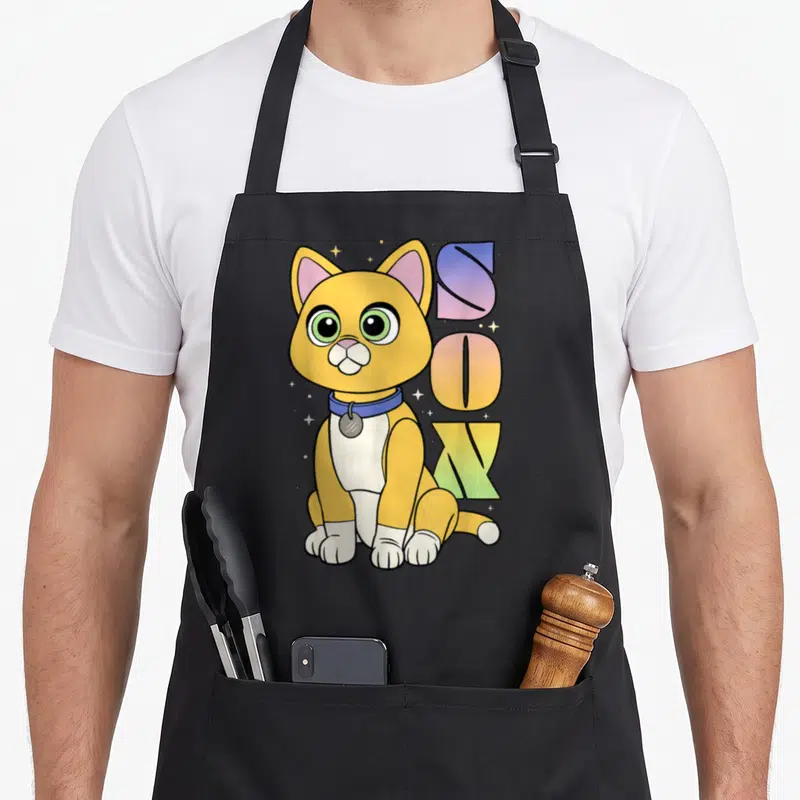Tablier de cuisine noir avec un chat jaune assis, des étoiles et le mot Sox en lettres colorées.