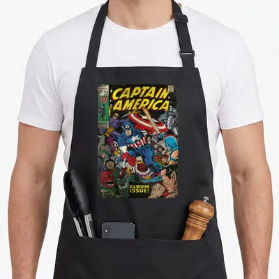 Tablier de cuisine noir avec une illustration colorée représentant Captain America au milieu d'un combat contre plusieurs ennemis dans un style comics vintage.