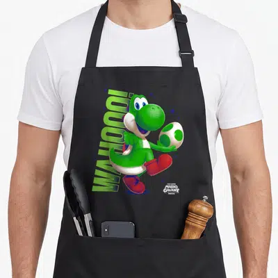 Tablier de cuisine noir avec Yoshi vert tenant un champignon blanc à pois verts et des chaussures rouges.