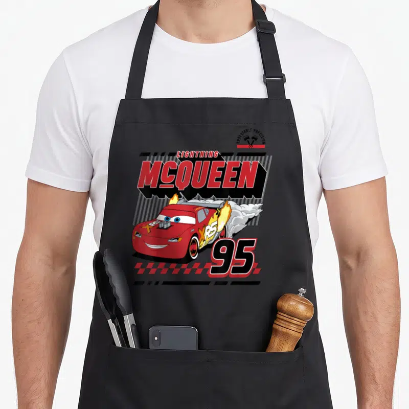 Tablier de cuisine noir avec illustration retro de la voiture rouge Lightning McQueen 95 et des flammes sortant des échappements.
