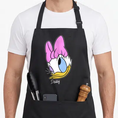 Tablier de cuisine noir avec illustration colorée de Daisy Duck et signature Daisy en bas.