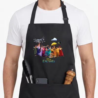 Tablier de cuisine noir avec le portrait de la famille Madrigal et le logo Encanto en bas.