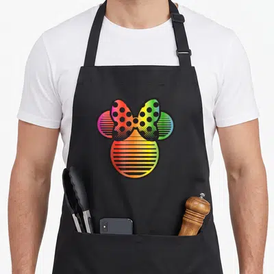 Tablier de cuisine noir avec tête de Minnie Mouse aux couleurs de l'arc-en-ciel et motifs graphiques.