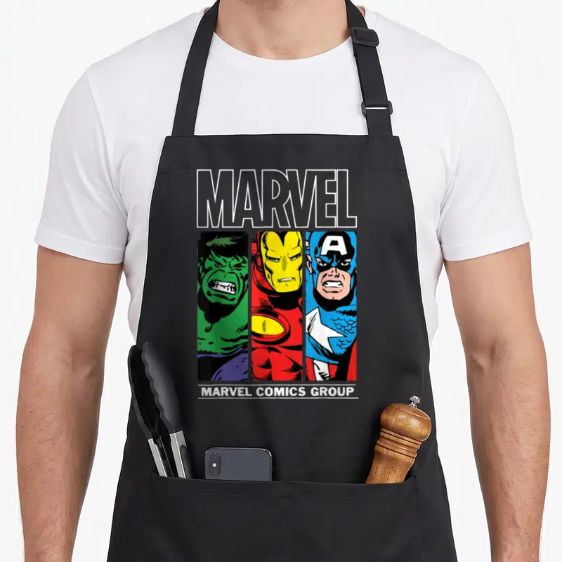 Tablier de cuisine noir avec illustration vintage Marvel Comics Group Hulk Iron Man Captain America en trois bandes colorées vertes rouges et bleues.