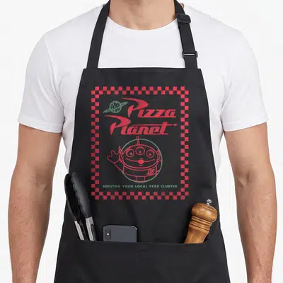 Tablier de cuisine noir avec le logo Pizza Planet et un alien rouge à trois yeux levant la main.