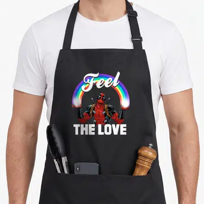 Tablier de cuisine noir avec Deadpool tendant les mains sous un arc-en-ciel et le texte Feel The Love en blanc.