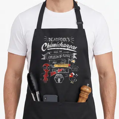 Tablier de cuisine noir avec illustration rouge de Deadpool tenant un plateau de chimichangas et une poule à côté.