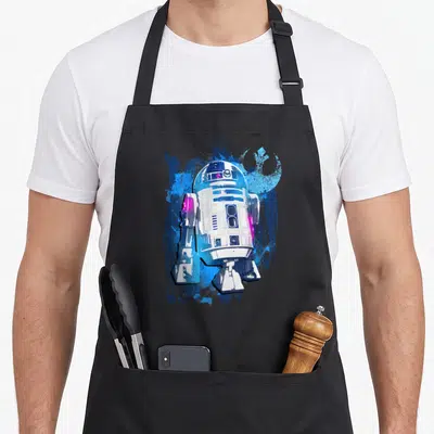 Tablier de cuisine noir avec illustration stylisée de R2-D2 en bleu et rose vif.