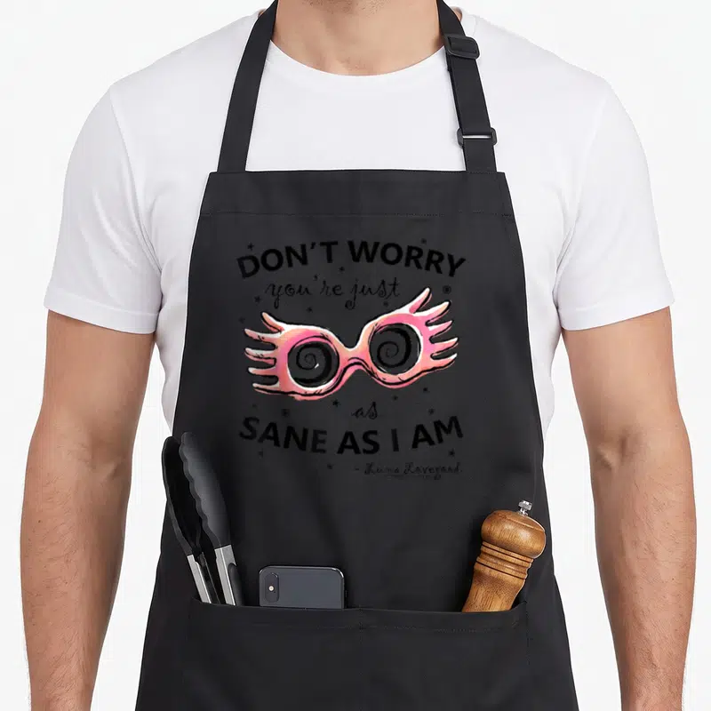Tablier de cuisine noir avec lunettes roses à spirales et texte Don't worry you're just as sane as I Am Luna Lovegood