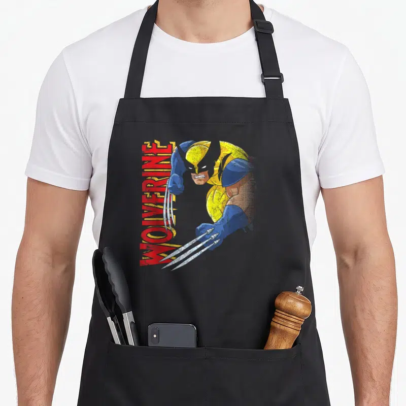 Tablier de cuisine noir avec illustration vintage de Wolverine en position d'attaque et son nom en lettres rouges verticales.