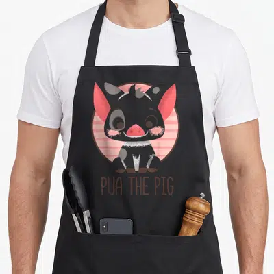 Tablier de cuisine noir avec illustration de Pua The Pig, cochon gris aux oreilles roses et texte en bas.