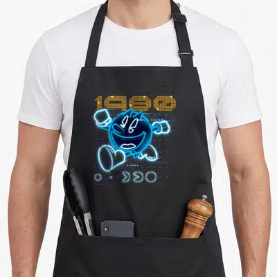 Tablier de cuisine noir avec illustration Pac-Man neon bleu et l'année 1980 en pixelisé orange.