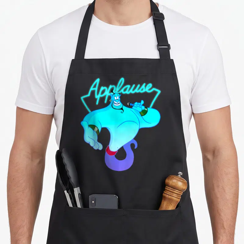 Tablier de cuisine noir avec le Genie d'Aladdin tenant un micro et le texte Applause en lettres néon bleues au-dessus.