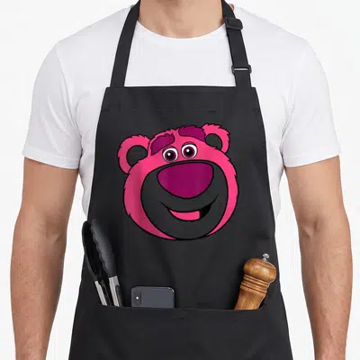 Tablier de cuisine noir avec le visage souriant de l'ours rose Lotso en illustration colorée et mignonne.