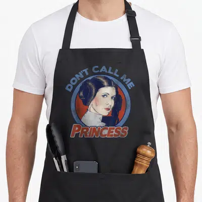 Tablier de cuisine noir avec illustration circulaire de Leia et texte Don't Call Me Princess.