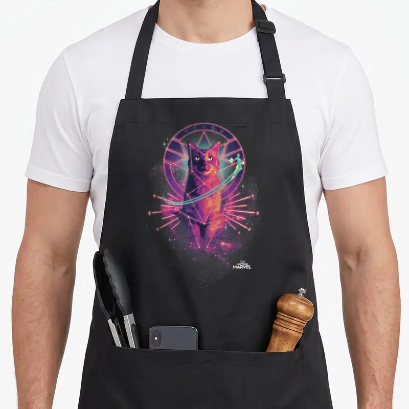 Tablier de cuisine noir avec portrait coloré de Goose entouré de symboles géométriques roses et violets ainsi qu'une silhouette verte volante.