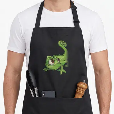 Tablier de cuisine noir avec une illustration de Pascal le petit caméléon vert aux grands yeux expressifs et à la queue en spirale.