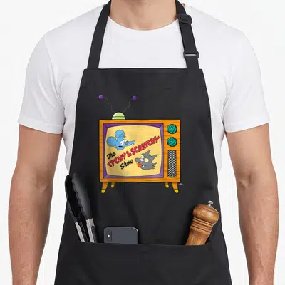 Tablier de cuisine noir avec une illustration de télévision rétro affichant un chat et un mouse en animation vintage.