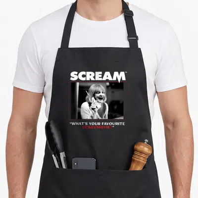Tablier de cuisine noir avec une illustration monochrome d'une femme au téléphone criant et le titre Scream en lettres blanches.