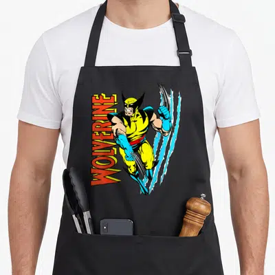 Tablier de cuisine noir avec illustration vintage Wolverine aux griffes et texte vertical rouge.