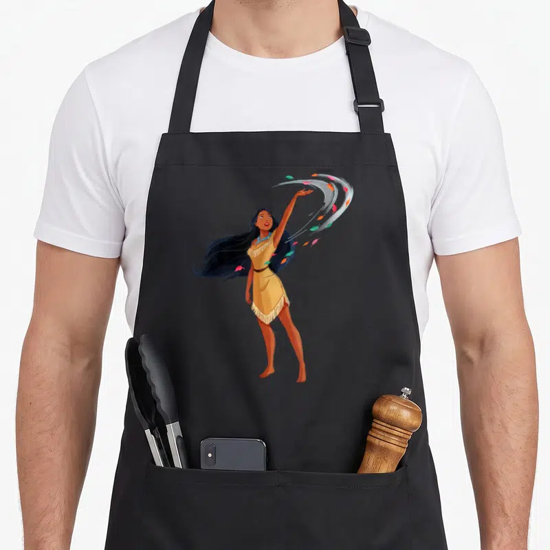 Tablier de cuisine noir avec illustration de Pocahontas aux cheveux noirs et robe jaune ornée de franges et de plumes colorées.