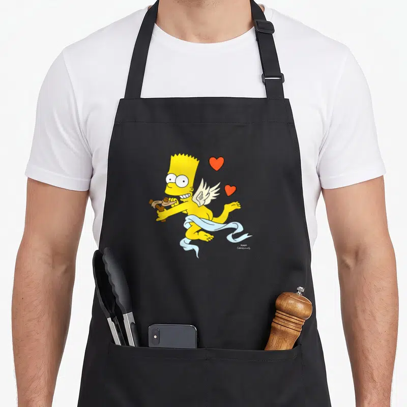 Tablier de cuisine noir avec Bart Simpson en chérub tenant une fronde et des cœurs rouges flottants.