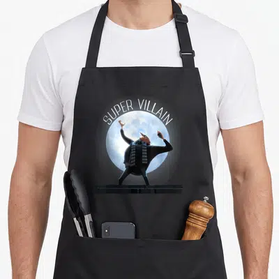 Tablier de cuisine noir avec l'image de Super Villain Gru debout sur un socle face à une grande lune bleue.