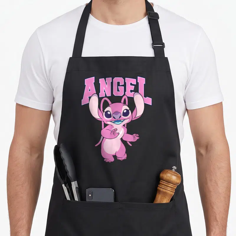 Tablier de cuisine noir avec une illustration rose d'Angel et le mot ANGEL en lettres capitales au-dessus.