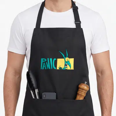 Tablier de cuisine noir avec le mot Panic en turquoise et un petit démon aux yeux écarquillés sortant d'un rectangle jaune.