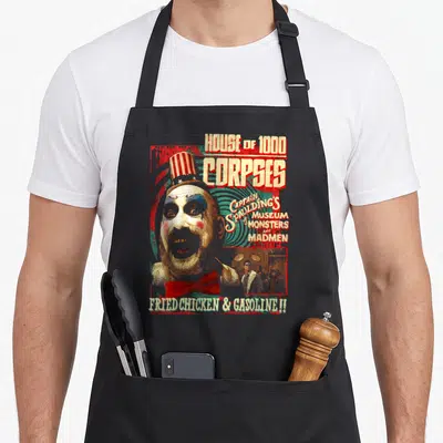 Tablier de cuisine noir avec illustration vintage du Capitaine Spaulding et textes House of 1000 Corpses et Fried Chicken & Gasoline.