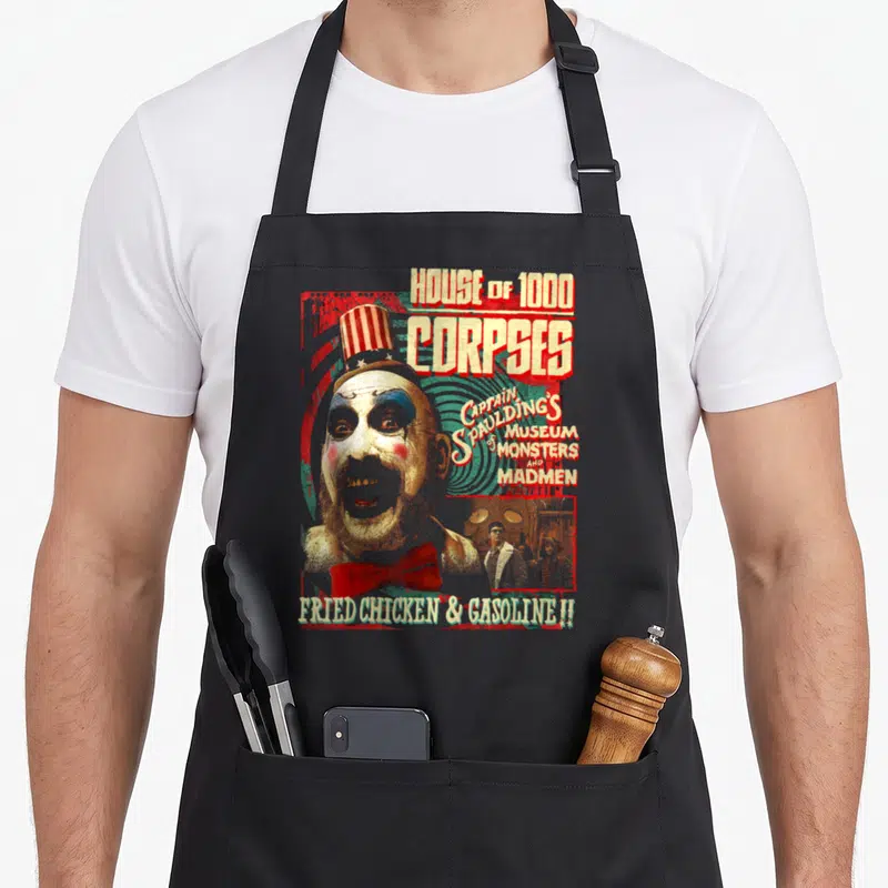 Tablier de cuisine noir avec illustration vintage du Capitaine Spaulding et textes House of 1000 Corpses et Fried Chicken & Gasoline.