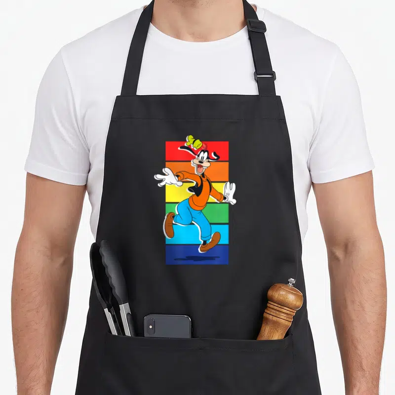 Tablier de cuisine noir avec un dingo souriant courant devant des bandes horizontales colorées rouge orange jaune vert bleu et violet.