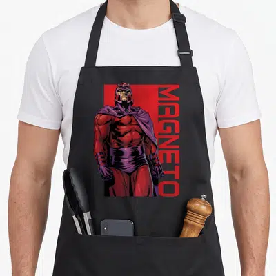 Tablier de cuisine noir avec illustration de Magneto en tenue rouge et cape violette, nom imprimé verticalement à droite.