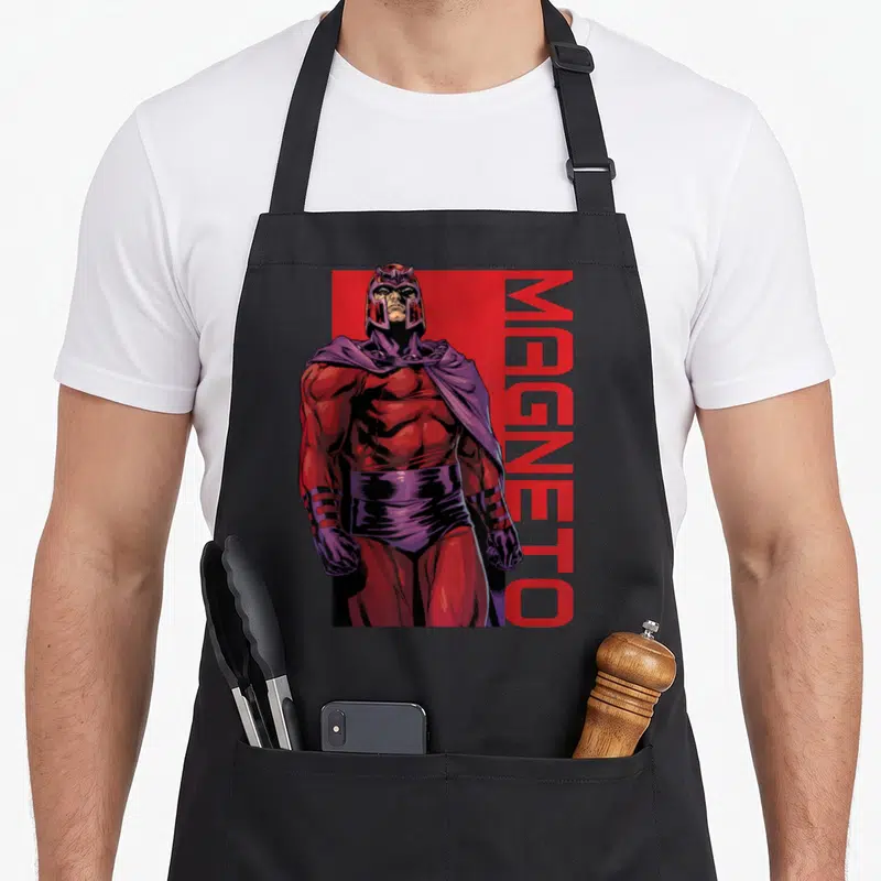 Tablier de cuisine noir avec illustration de Magneto en tenue rouge et cape violette, nom imprimé verticalement à droite.
