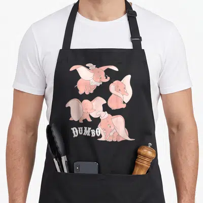 Tablier de cuisine noir avec quatre éléphants roses Dumbo et le texte Dumbo en typographie blanche.